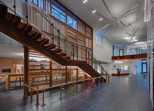 A wooden staircase with a metal railing leads to a second floor.