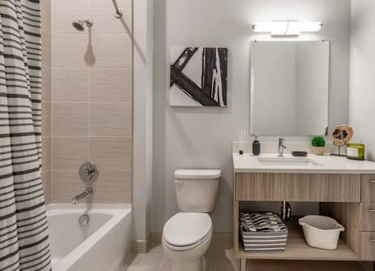 A bathroom with a toilet, sink, and a shower curtain.
