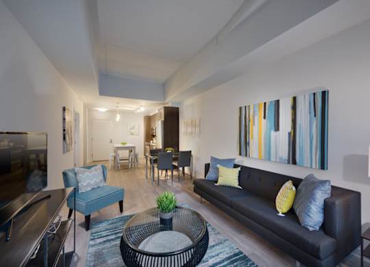 A living room with a black couch and a blue chair.