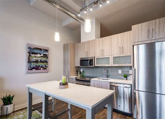 A modern kitchen with a stainless steel refrigerator and wooden cabinets.