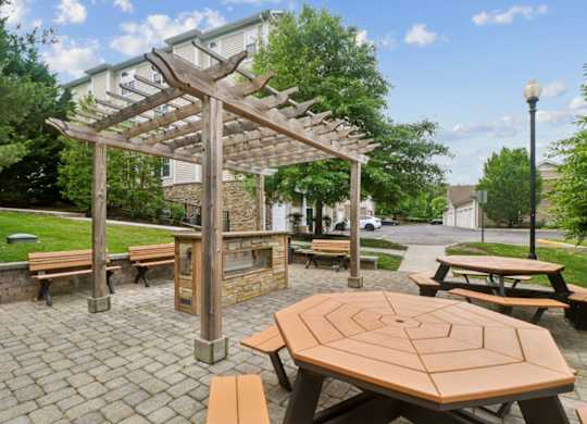 A wooden pergola is over a picnic table.