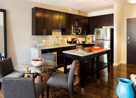 A kitchen with an island and table in front.