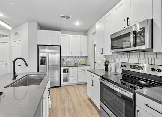 A modern kitchen with stainless steel appliances and white cabinets.