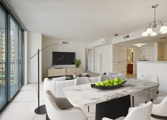 a living room and dining room with white chairs and a marble table