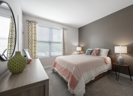 a bedroom with a bed and a dresser and a window