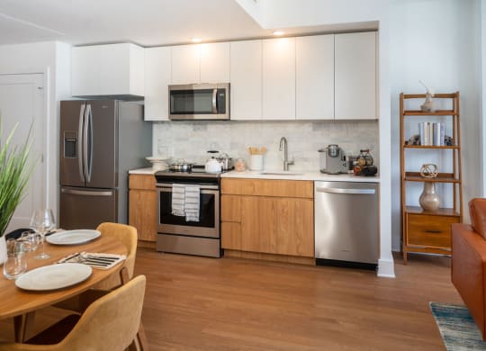 a kitchen with stainless steel appliances and a wooden table