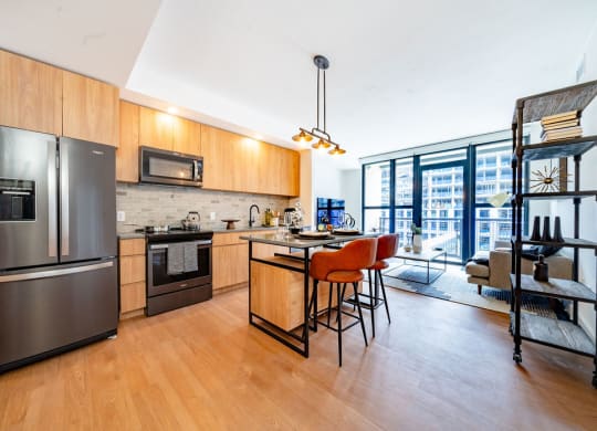 a kitchen with stainless steel appliances and a bar with chairs