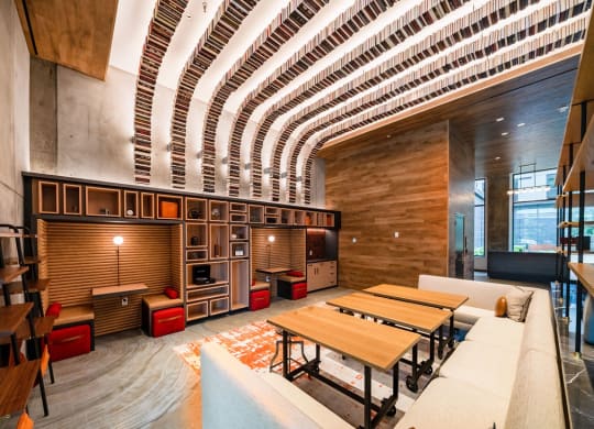 a large living room with tables and a kitchen in a lobby
