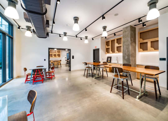 a large room with tables and chairs and a kitchen
