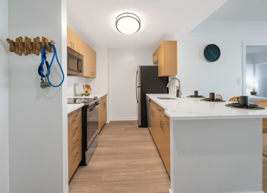 a kitchen with a white counter top and a black refrigerator