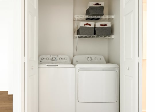 a white washer and dryer in a white laundry room