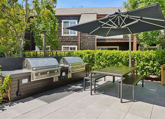 Outdoor grilling area at Sunnyvale apartments with landscaped surroundings