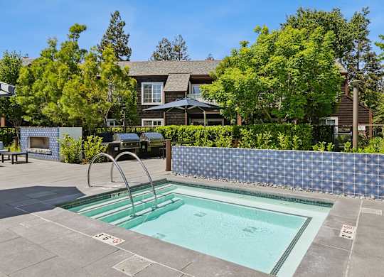 Outdoor hot tub at Grove Apartments with surrounding seating and greenery