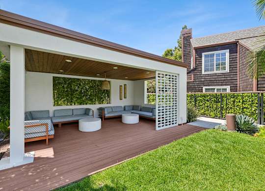 Covered poolside cabana at Grove Apartments with lounge seating and landscaped surroundings.