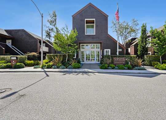 Exterior of Grove Apartments with leasing office, landscaped entry, and mature trees.