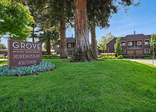 Grove Apartments community sign surrounded by landscaped grounds and mature trees.