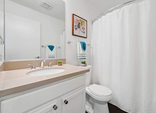 Bathroom at Grove Apartments with vanity storage, full-size tub, and modern fixtures.