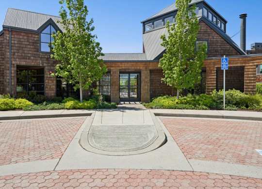 Exterior entrance of Indian Creek Apartments with landscaped walkway and wood-style architecture.