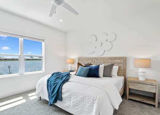 A bedroom with a large bed and a view of the water at Marisol in Lakewood Ranch, FL