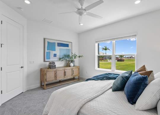A bedroom with a large bed and a ceiling fan at Marisol in Lakewood Ranch, FL