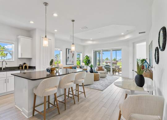 A modern kitchen with white cabinets and a large island at Marisol in Lakewood Ranch, FL