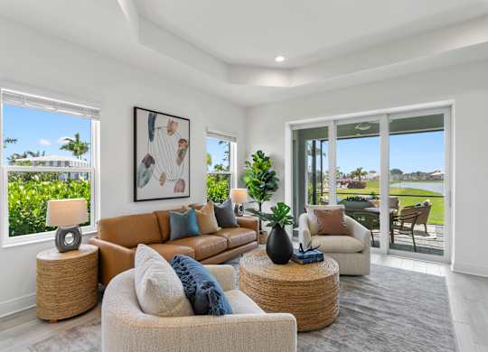 A well-lit living room with a large window and a view of a green lawn at Marisol in Lakewood Ranch, FL