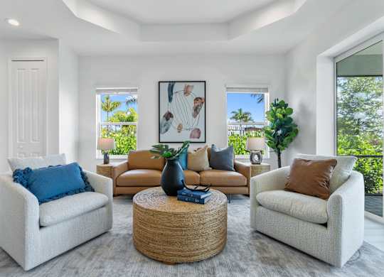 A living room with a white couch, a brown couch, and a coffee table at Marisol in Lakewood Ranch, FL