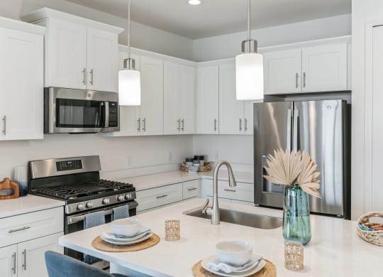 a kitchen with white cabinets and stainless steel appliances at Marisol, Bradenton, FL 34211
