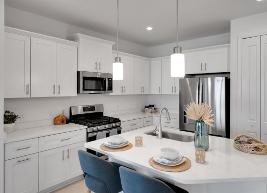 a kitchen with white cabinets and a marble counter top at Marisol, Bradenton FL