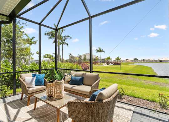 A patio with a table and chairs overlooking a body of water at Marisol in Lakewood Ranch, FL