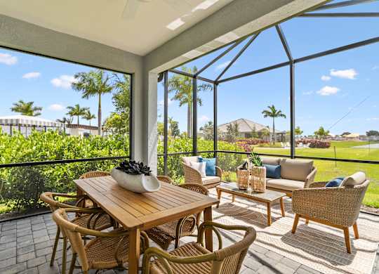 A patio with a table and chairs overlooking a lush green landscape at Marisol in Lakewood Ranch, FL
