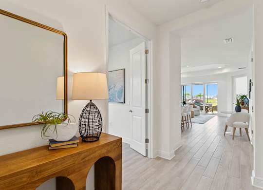 A room with a wooden table and a mirror on the wall at Marisol in Lakewood Ranch, FL