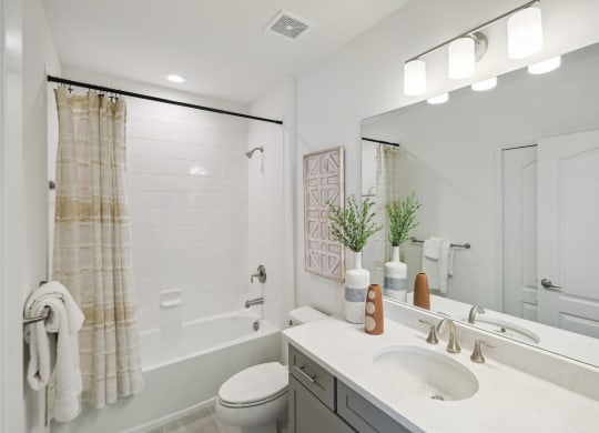 Upstairs bathroom with tub and spacious vanity in 3 bedroom rental home