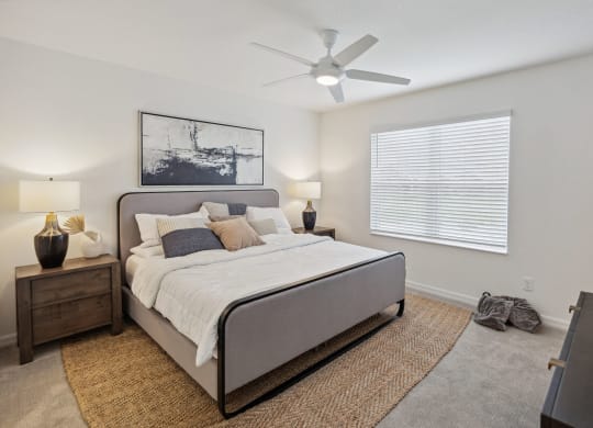 Large bedroom with ceiling fan and window in 3 bedroom home