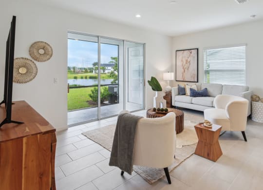Living room furniture and view of patio and lake at  Martinique Lakewood Ranch model home