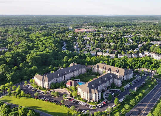An aerial view of a large apartment complex surrounded by greenery and roads.