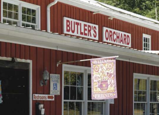 A red building with a sign that says Butler's Orchard.