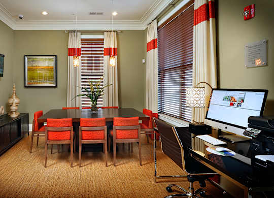 A conference room with a long table and chairs, a computer desk, and a printer.