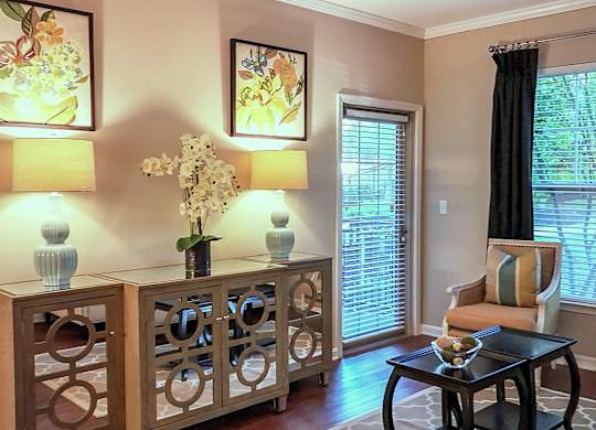 A living room with a table, chairs, and two lamps.
