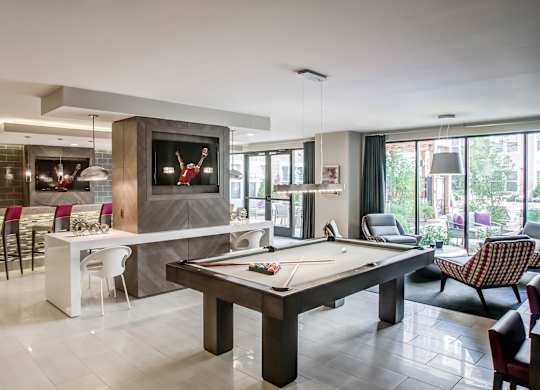 A room with a pool table and a television.