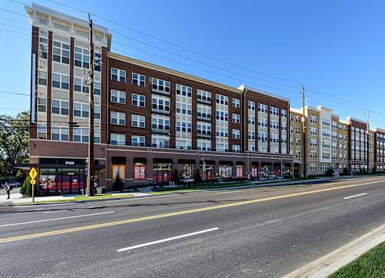 A street view of a multi-story building with a clear blue sky above.