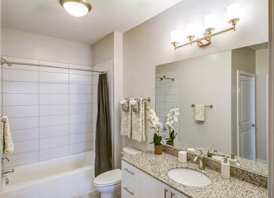 A bathroom with a white tub, sink, and toilet.