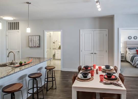 A kitchen with a bar and a dining table set for two.