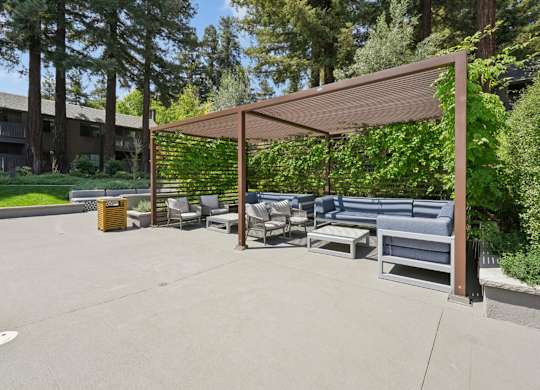 Poolside cabana with seating and nearby swimming pool at Old Orchard Apartments