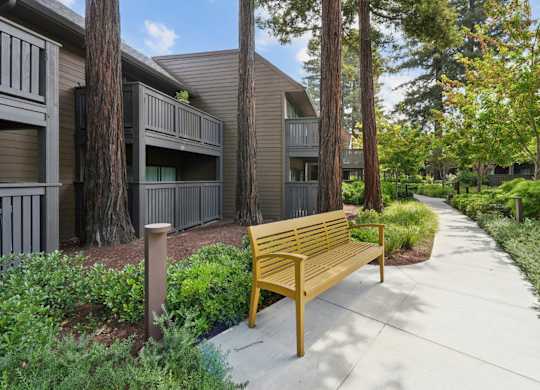 Landscaped community walkway leading to residential buildings with trees at Old Orchard Apartments