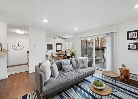 Living room with sofa, TV, coffee tables, and sliding glass door leading to patio