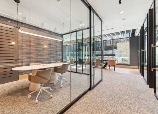 a conference room with glass walls and a table and chairs