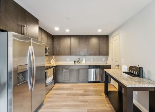 A kitchen with hardwood floor and a fridge