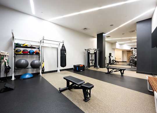 a gym with weights and other equipment on the floor and a tv