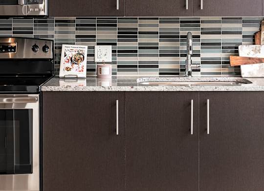 A kitchen with brown cabinets and a stainless steel oven.